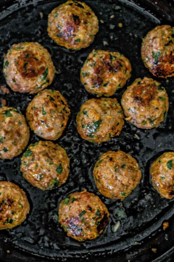 Keto Greek meatballs in a cast iron pan.