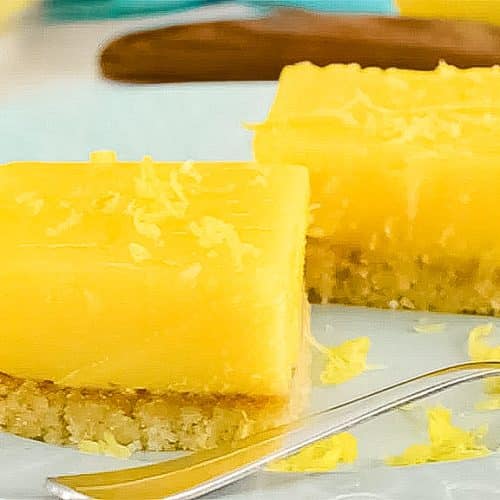 Two keto lemon bars on a plate.