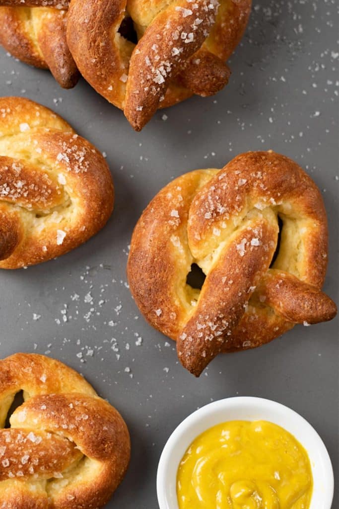 Low-Carb Keto soft pretzels and mustard sauce on a tray with text saying Soft and delicious, free recipe.