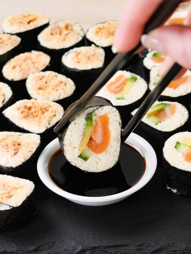 The best keto sushi rolls with cauliflower rice being dipped in tamari sauce.