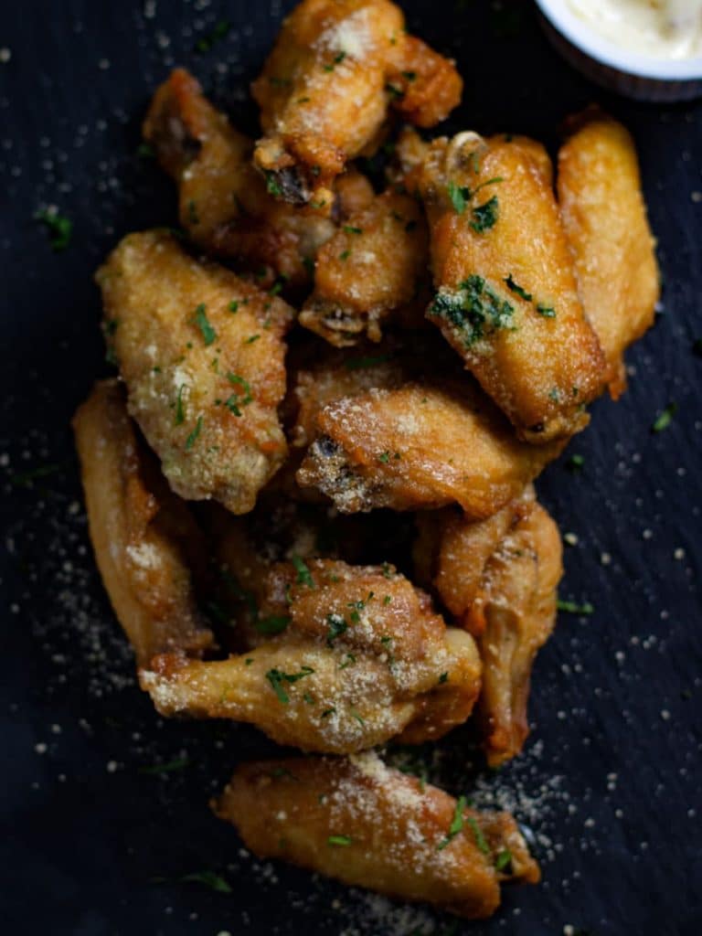 Parmesan chicken wings on a tray.