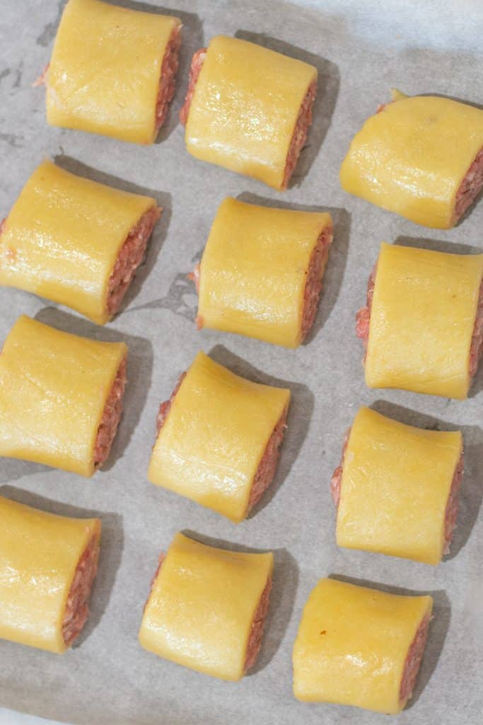 Keto sausage rolls pastry on a baking tray with baking paper.