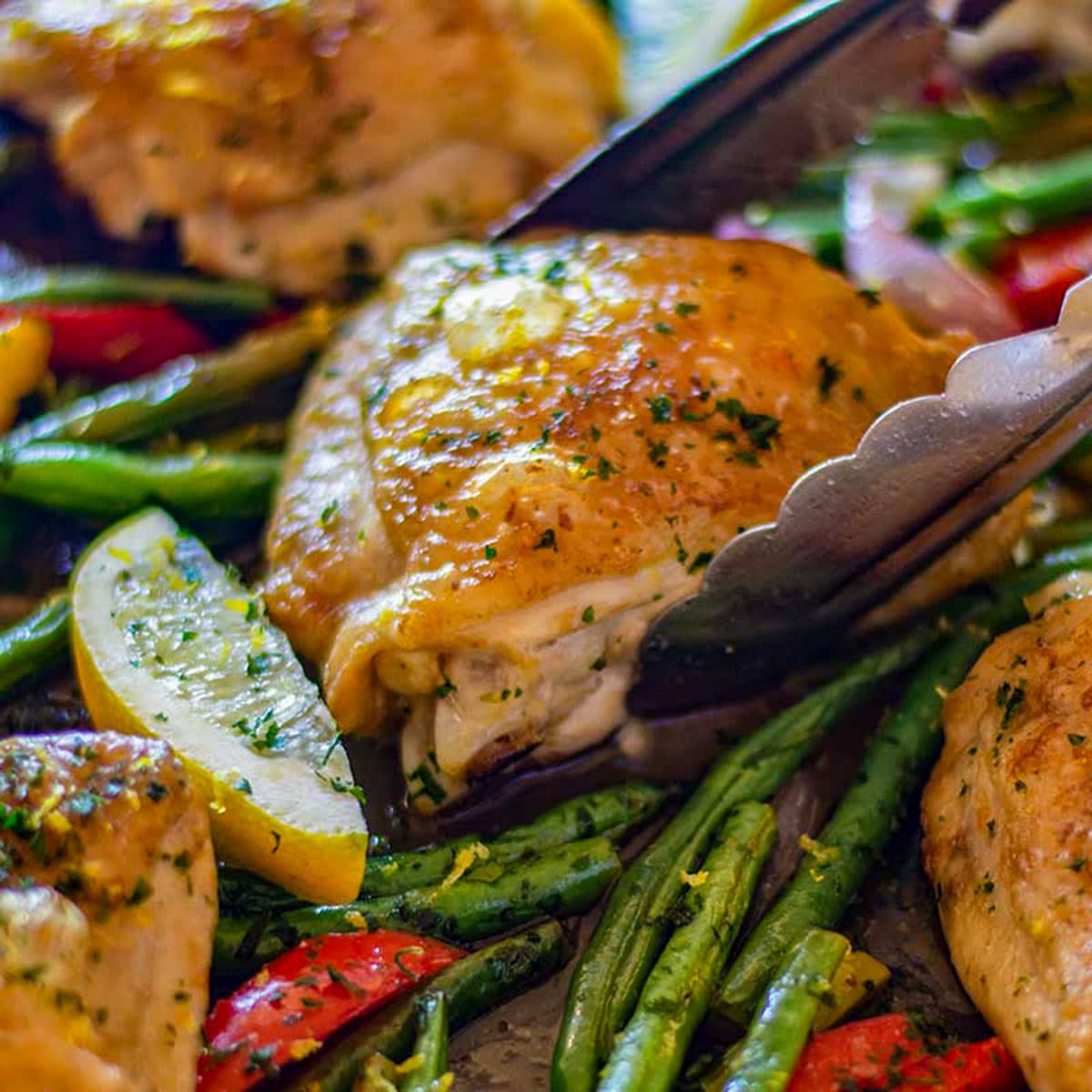 Chicken thigh on a pan with green beans.