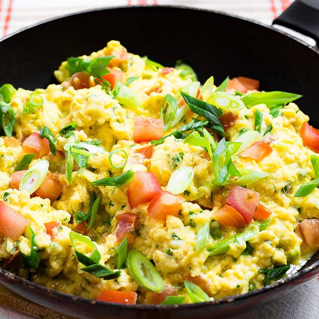 Salsa scrambled eggs in a frying pan.