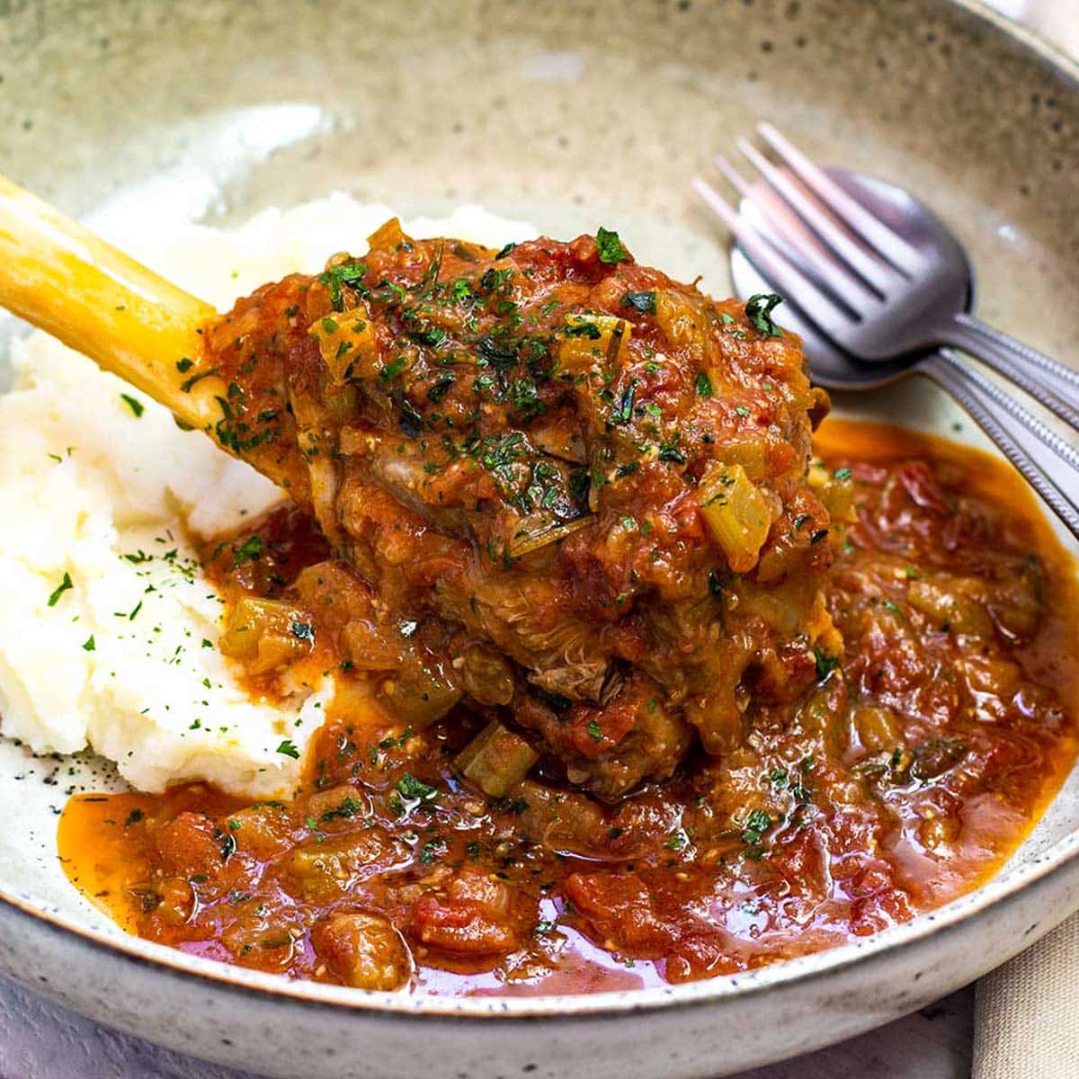 Keto slow cooker lamb shanks in a bowl with cauliflower mash.