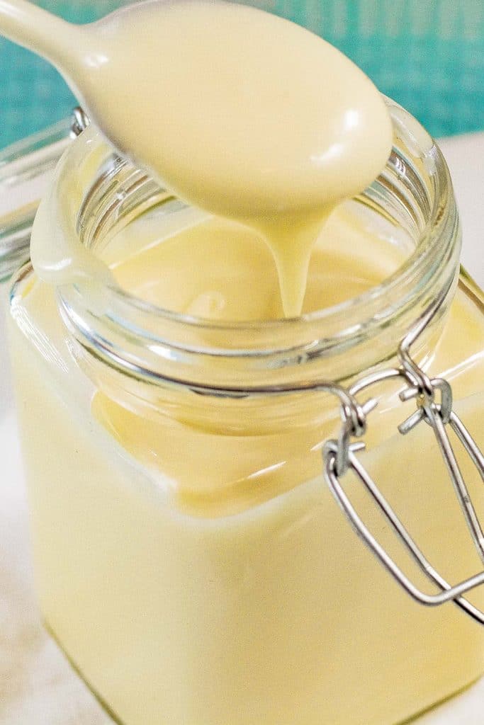 Spoon full of keto mayonnaise from a mason jar.