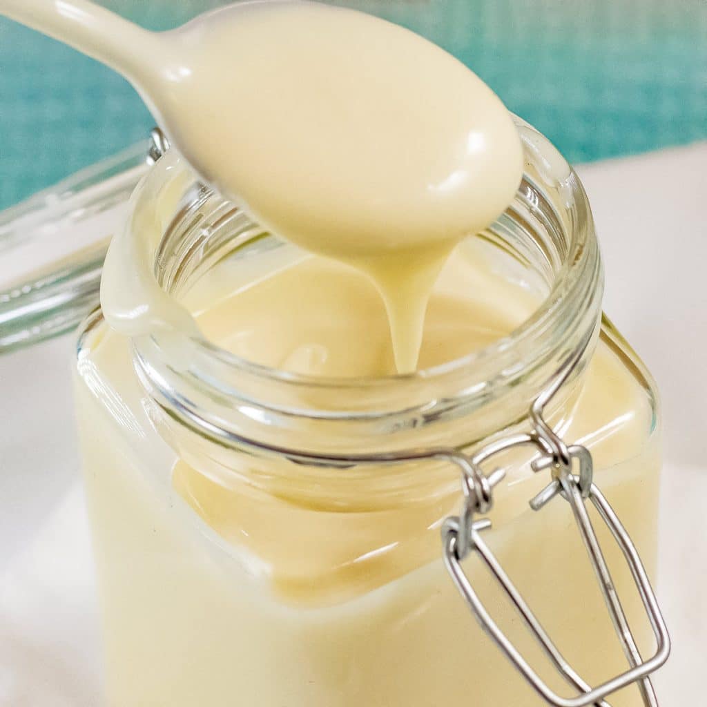 Spoon full of keto mayonnaise form a mason jar.