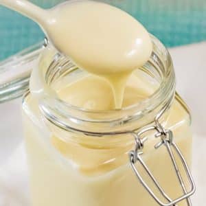 Spoon full of keto mayonnaise form a mason jar.