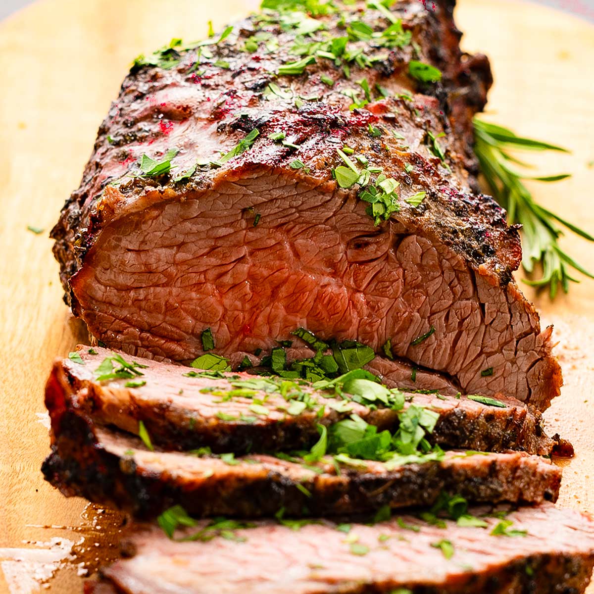 Keto beef tri-tip sliced on a chopping board.