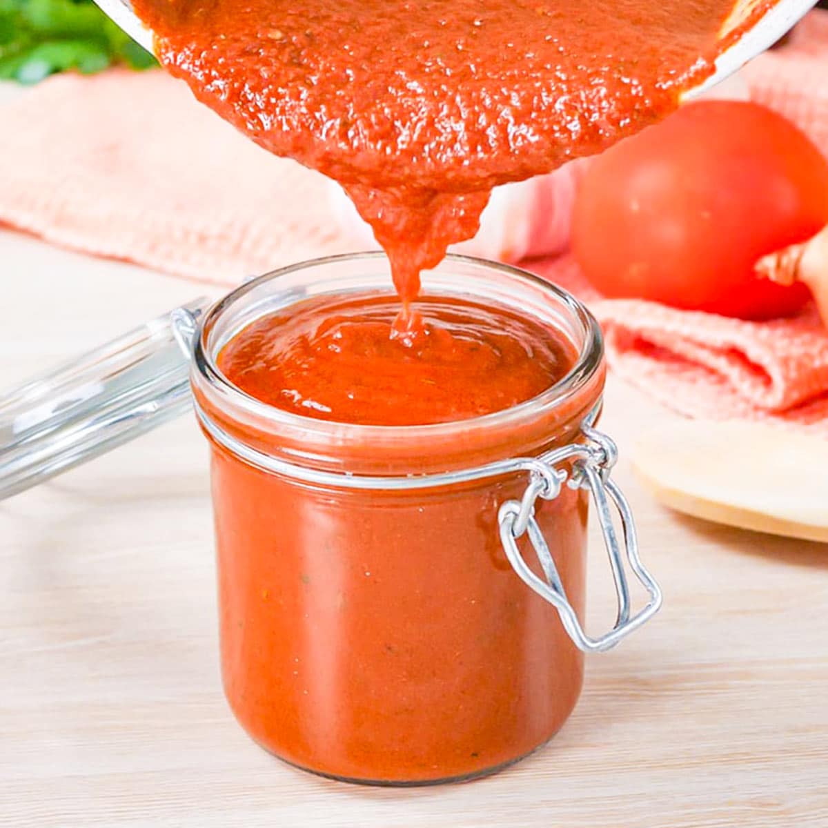 Keto enchilada sauce being poured into a mason jar.